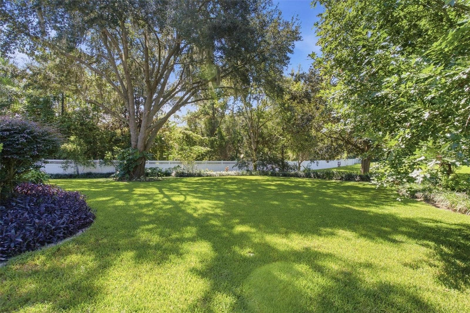 8732 SPRING COURT, Leesburg, FL 34788 Backyard is partially fenced and beautifully landscaped.