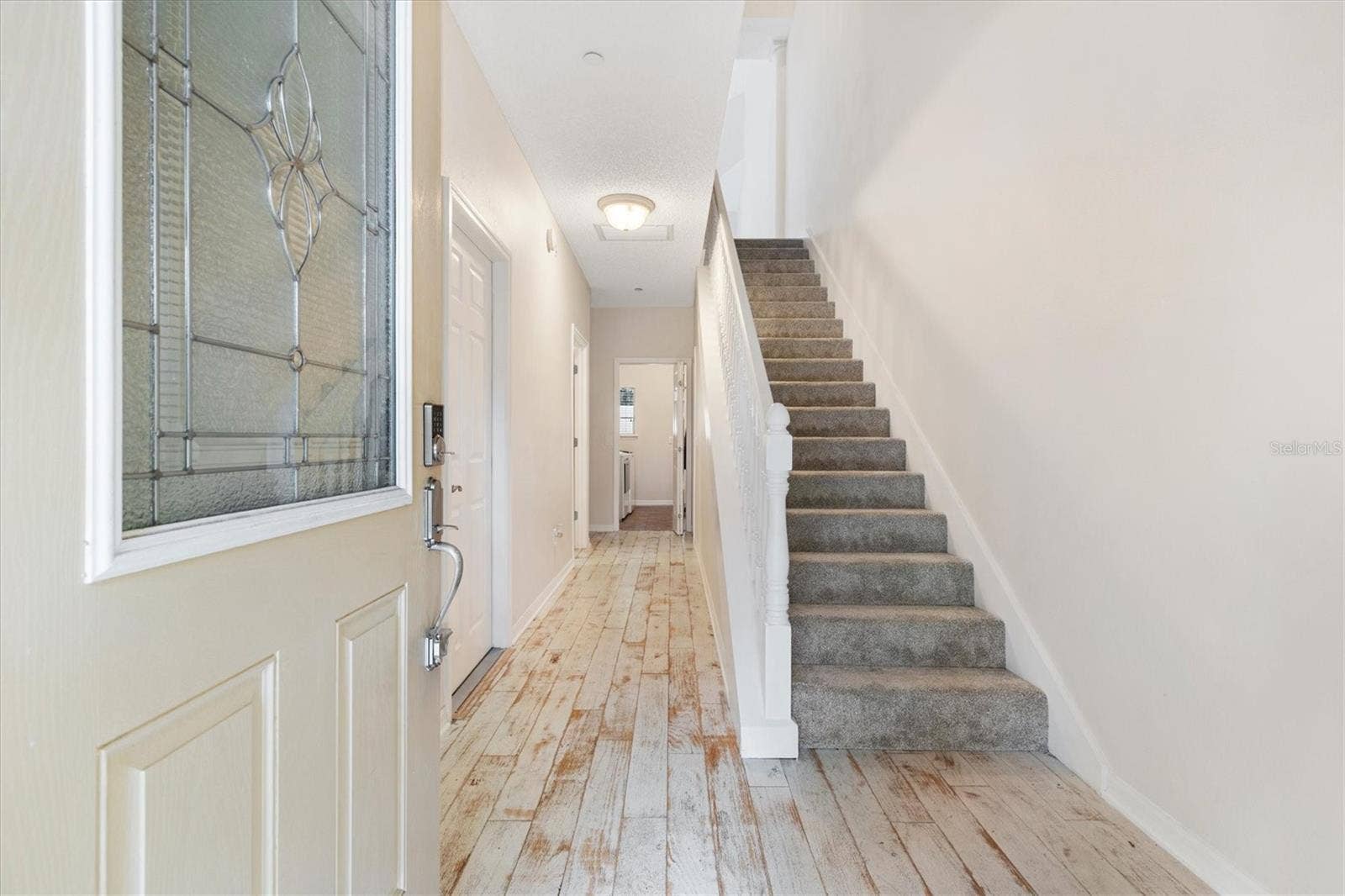1sr Floor-Foyer w/ Distressed Engineered Wood Flooring. Carpet padded stairs.