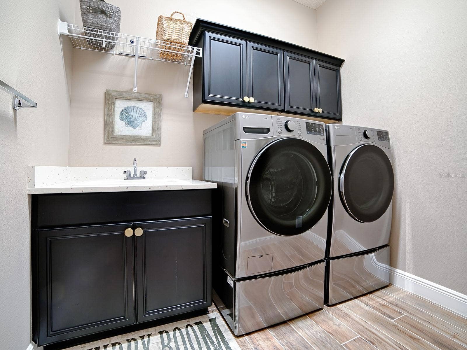 3075 LICCIARDELLO PATH, The Villages, FL 32163 THE LAUNDRY ROOM IS IN THE HALLWAY THAT LEADS TO THE 2ND GUEST SUITE. QUARTZ COUNTERTOPS, BUILT-IN SINK AND EXTRA CABINETS FOR MORE STORAGE SPACE. THE FRONT LOAD WASHER AND DRYER DO CONVEY.