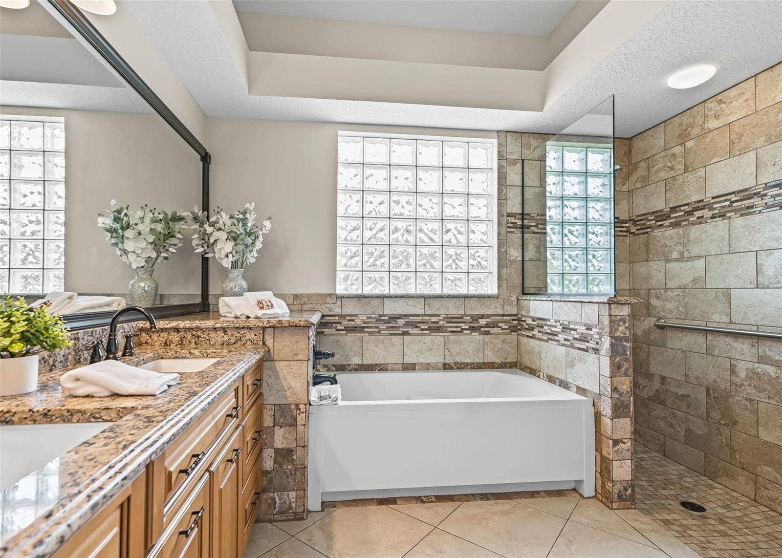 Primary Bathroom with tub and roman shower