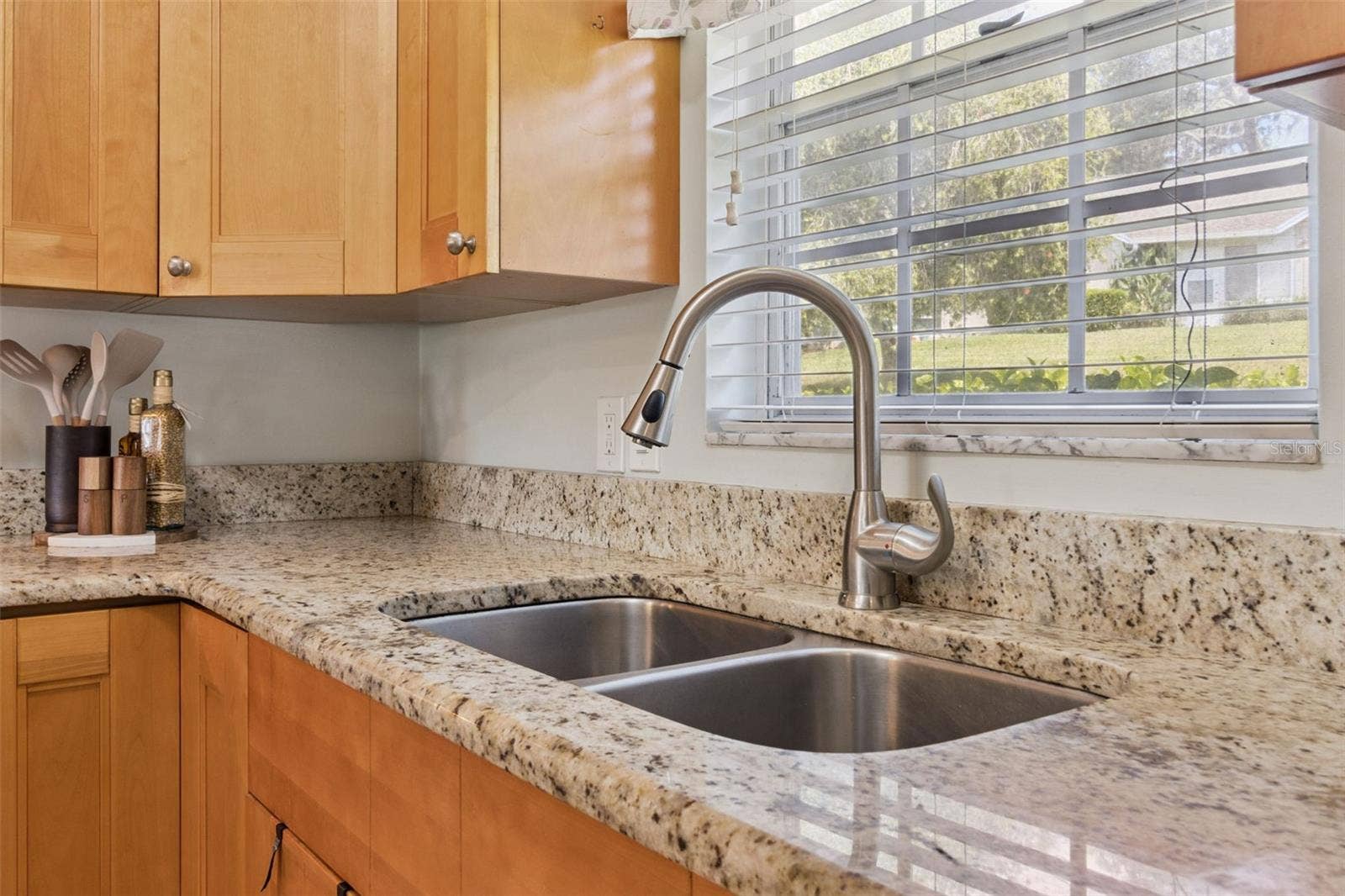 1066 VILLA LANE, #63, Apopka, FL 32712 Culinary hosts appreciate the 42" cabinets to the ceiling, pull-out shelves, lazy Susan, and window that brings in natural sunlight over the deep, double kitchen sink.