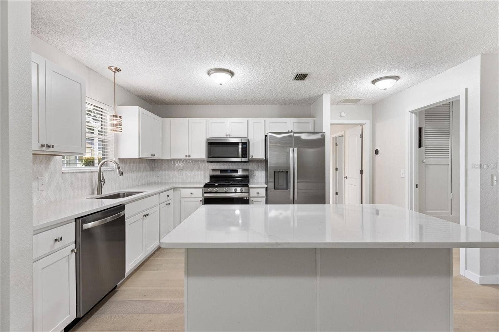 9595 SE 171ST ARGYLL STREET, The Villages, FL 32162 Kitchen with new Shaker Cabinets, Stainless Steel Appliances, & Quartz Countertops.