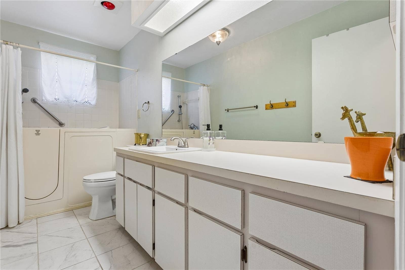 Guest bath with a walk-in tub for soaking those aching muscles.