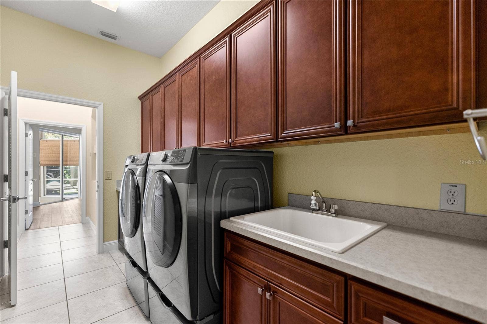 Indoor Laundry Room with Custom Cabinetry, Utility Sink, and Folding Counter.