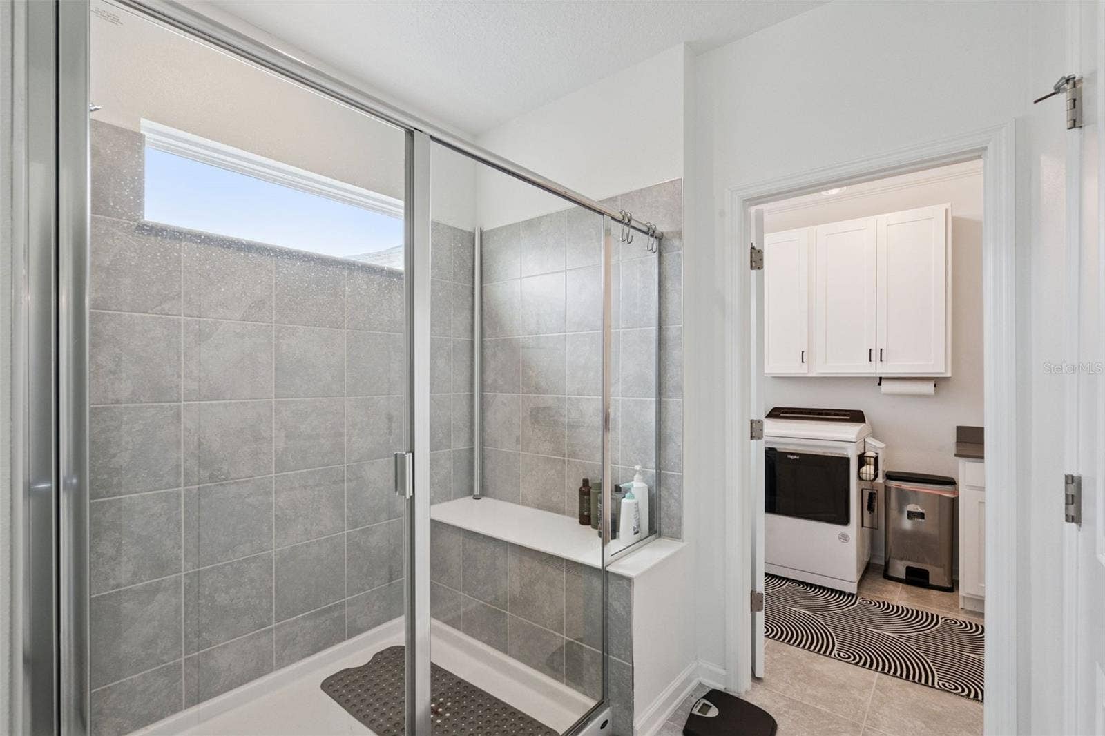 6175 SHAVASANA RD ROAD, Clermont, FL 34714 Owner's suite bathroom shower with built in seating, easy access into the laundry room