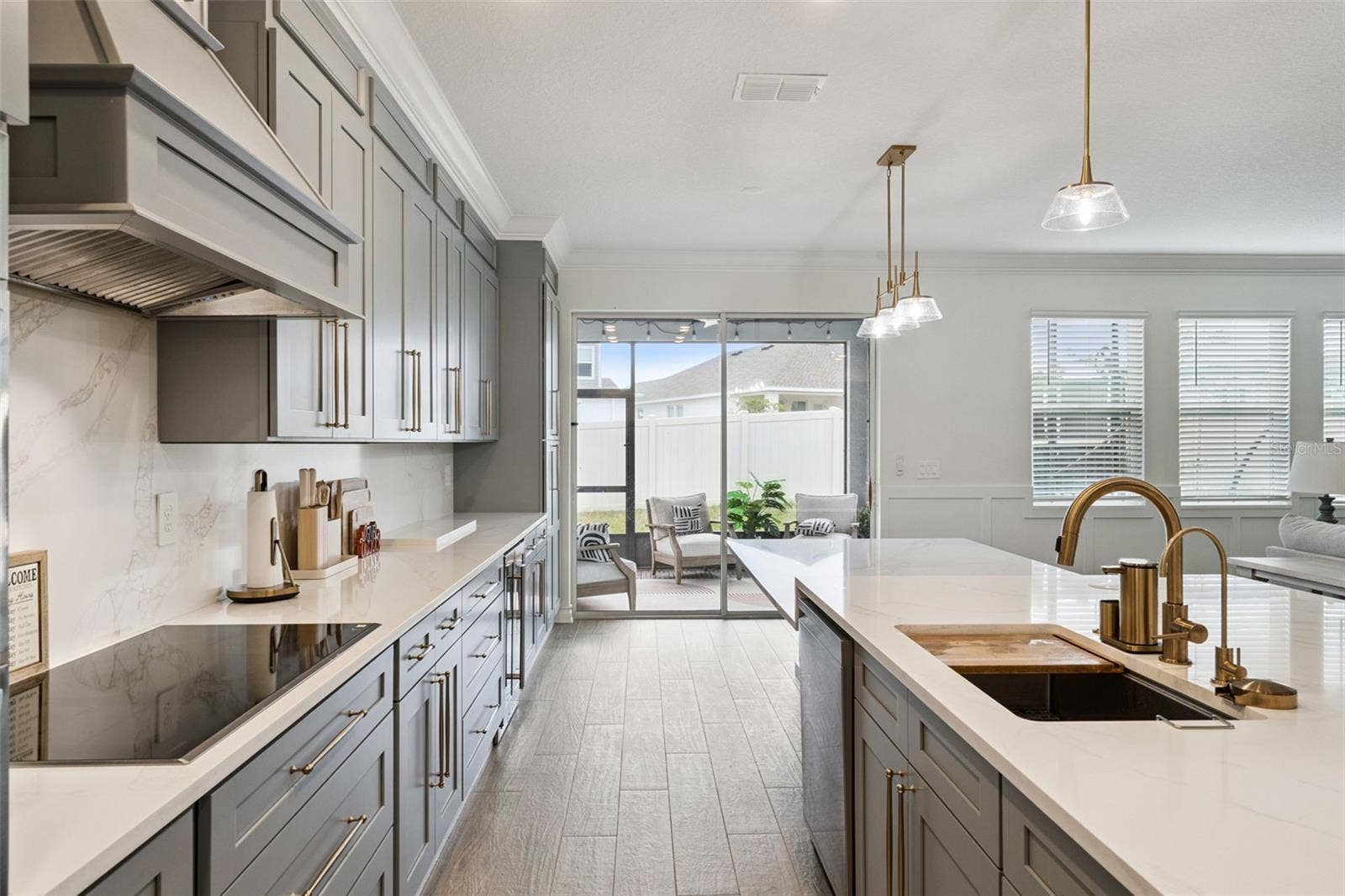 6175 SHAVASANA RD ROAD, Clermont, FL 34714 Marble backsplash, upgraded 36" smart induction cooktop with wifi and virtual flame technology, custom designer vent hood kitchen floor to ceiling custom cabinetry and fnishes , beautiful quartz counter tops