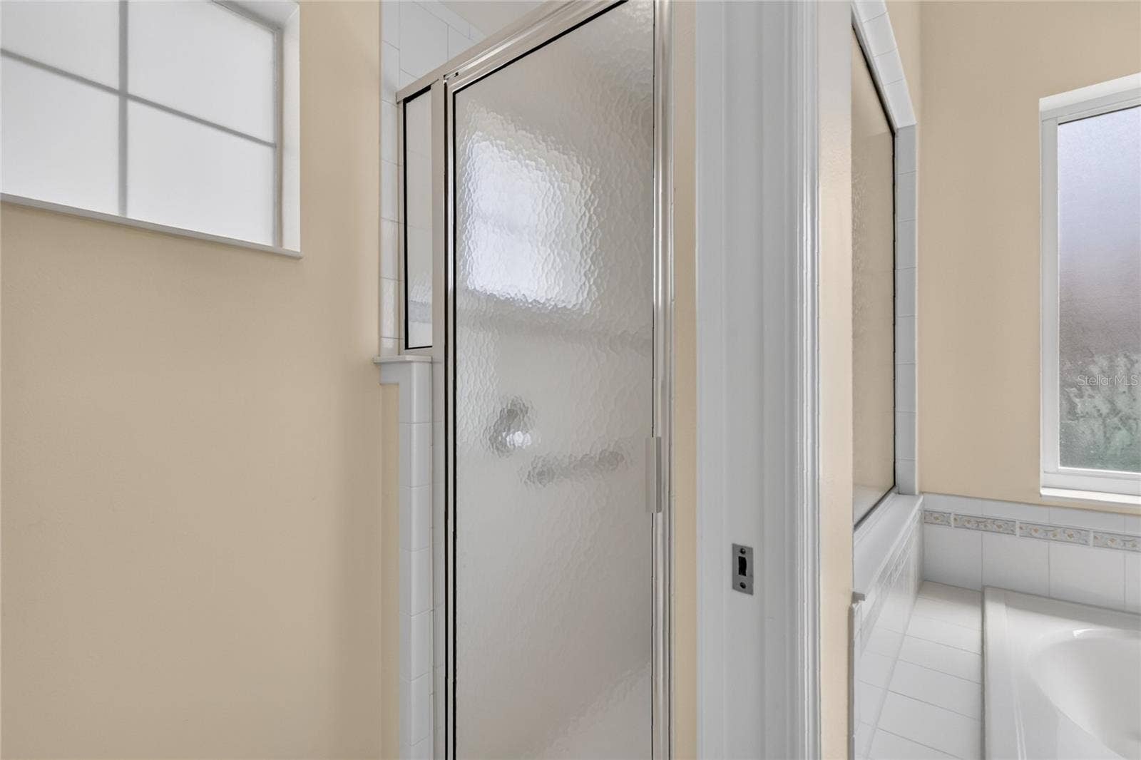 The walk in shower is separate from the tub and sink area.