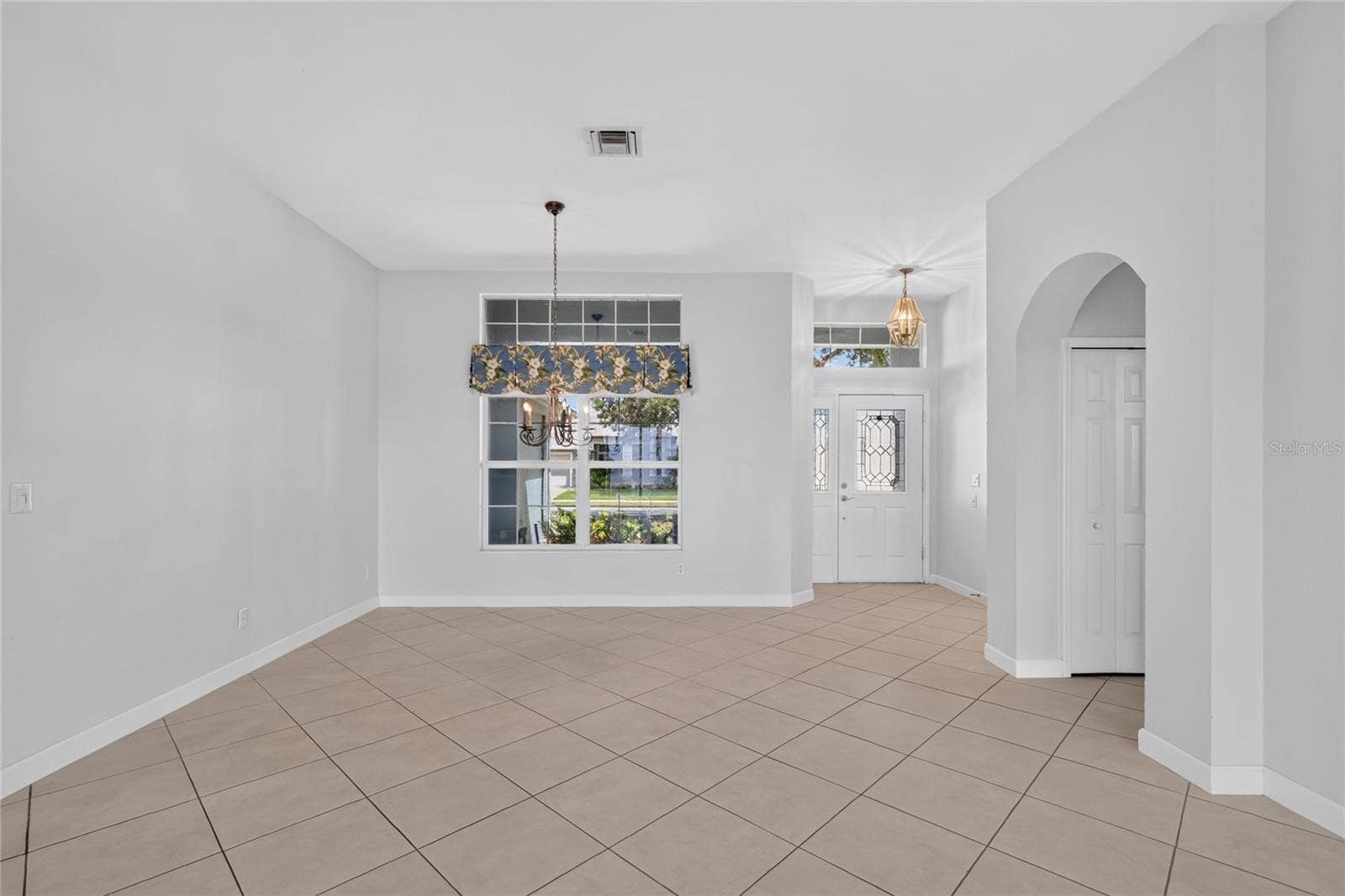 The dining room has a beautiful chandelier and a window to the covered front porch.