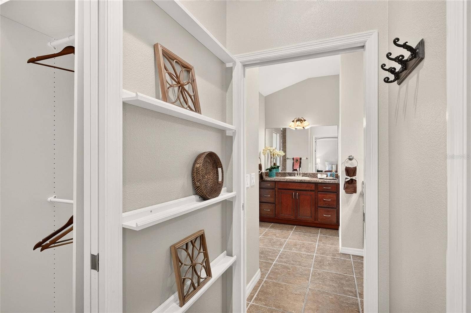2454 MORNING DOVE LANE, The Villages, FL 32162 CUSTOM CLOSET shelving and multiple hanging rods keep wardrobe essentials organized, with convenient access to the PRIMARY BATH.