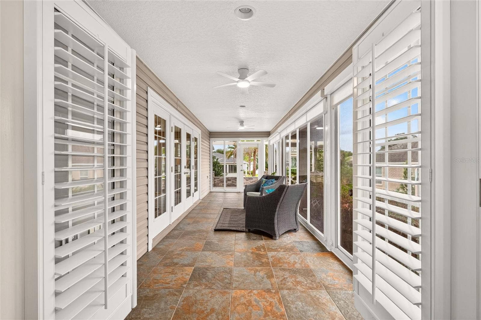 2454 MORNING DOVE LANE, The Villages, FL 32162 Step from the PRIMARY SUITE through the French Doors into the bright ENCLOSED LANAI, an inviting retreat for morning coffee, quiet moments, and year-round relaxation.