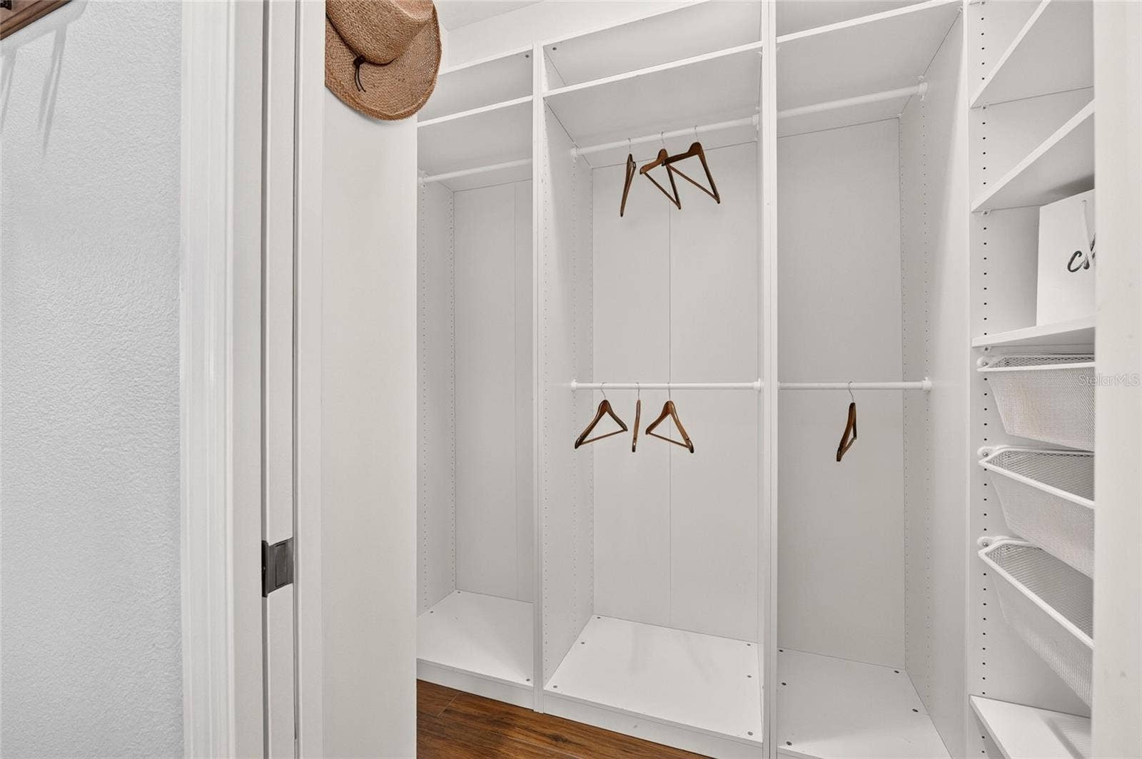 2454 MORNING DOVE LANE, The Villages, FL 32162 A beautifully organized CUSTOM WALK-IN CLOSET features adjustable shelving, multiple hanging rods, and pull-out baskets to keep clothing and accessories neatly within reach.