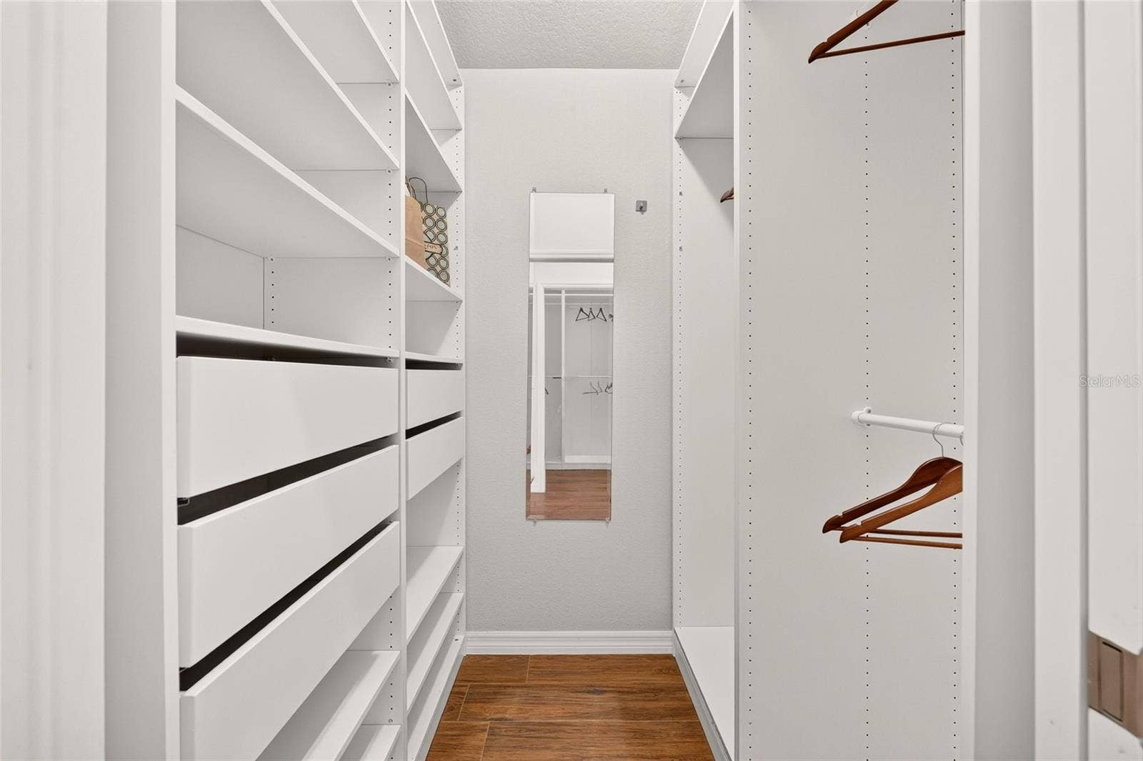 2454 MORNING DOVE LANE, The Villages, FL 32162 A beautifully organized CUSTOM WALK-IN CLOSET features adjustable shelving, multiple hanging rods, and pull-out baskets to keep clothing and accessories neatly within reach.