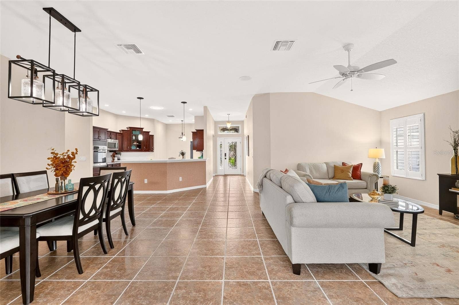 2454 MORNING DOVE LANE, The Villages, FL 32162 The bright, OPEN FLOOR PLAN brings the kitchen, dining, and living areas together beneath VOLUME CEILINGS, offering plenty of room to gather, entertain, and unwind.