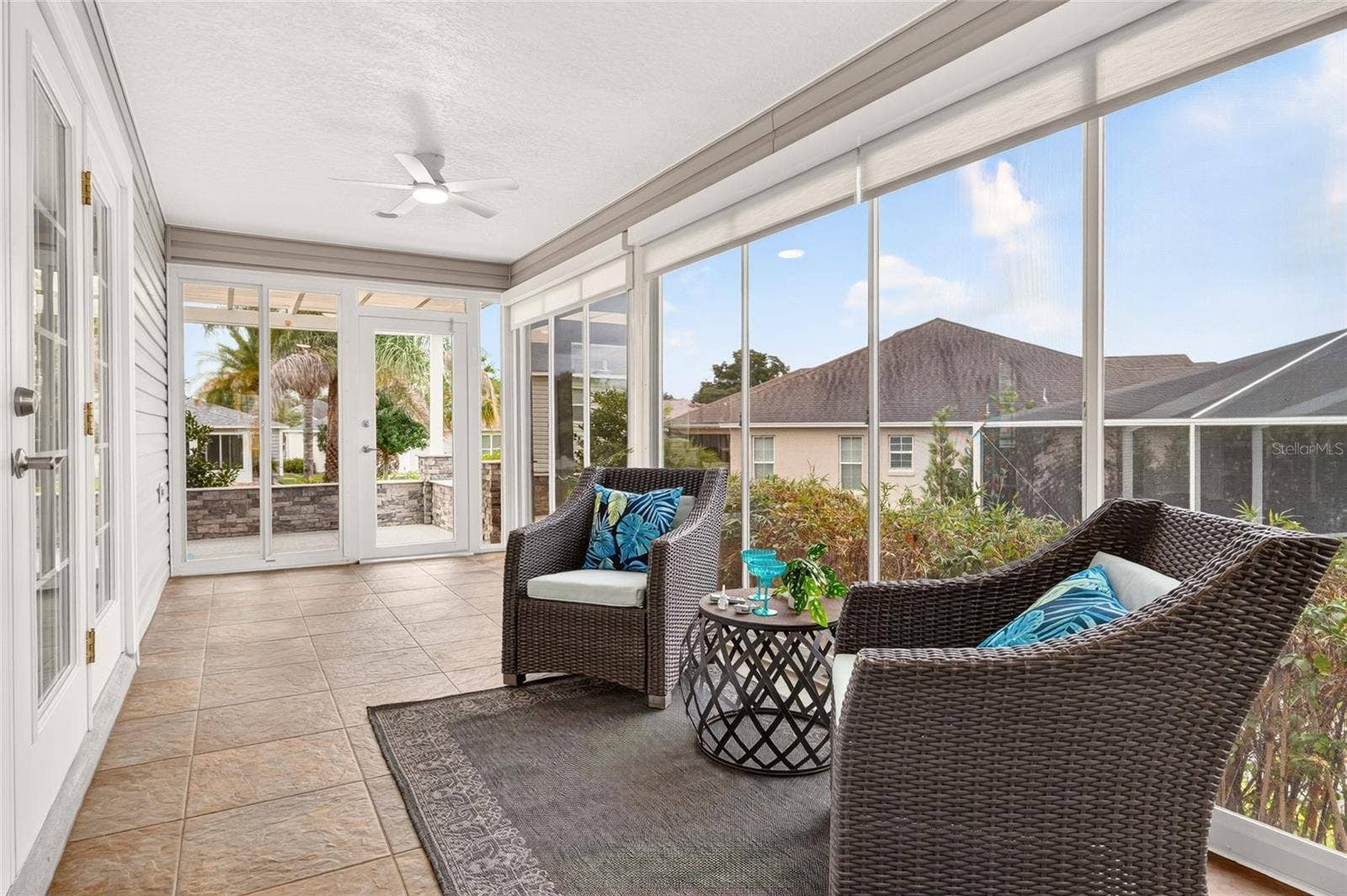 2454 MORNING DOVE LANE, The Villages, FL 32162 Bask in natural light in the ENCLOSED LANAI, featuring TILE FLOORING, expansive windows, and easy access to the PERGOLA PATIOan inviting setting for morning coffee or relaxing with friends.