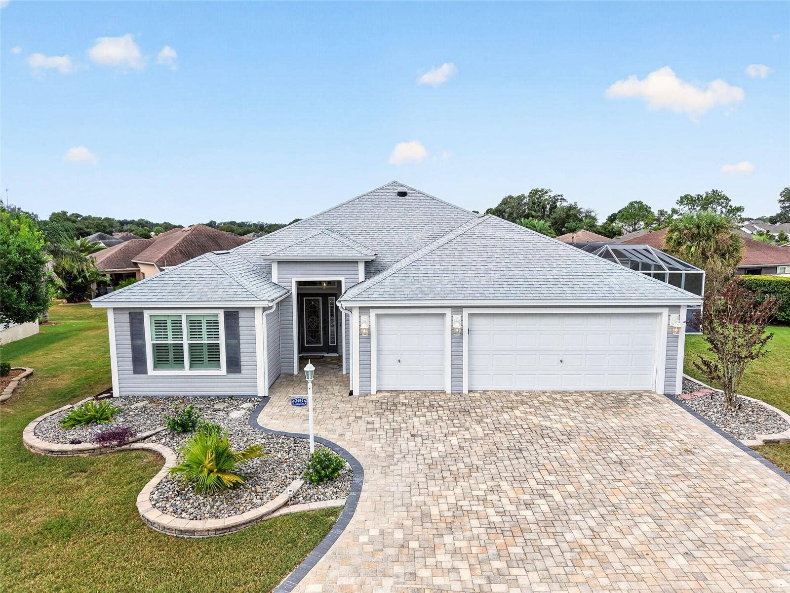 2454 MORNING DOVE LANE, The Villages, FL 32162 Beautifully tiered landscaping and a charming paver driveway welcome you home. A two-car garage plus golf cart garage adds everyday convenience.