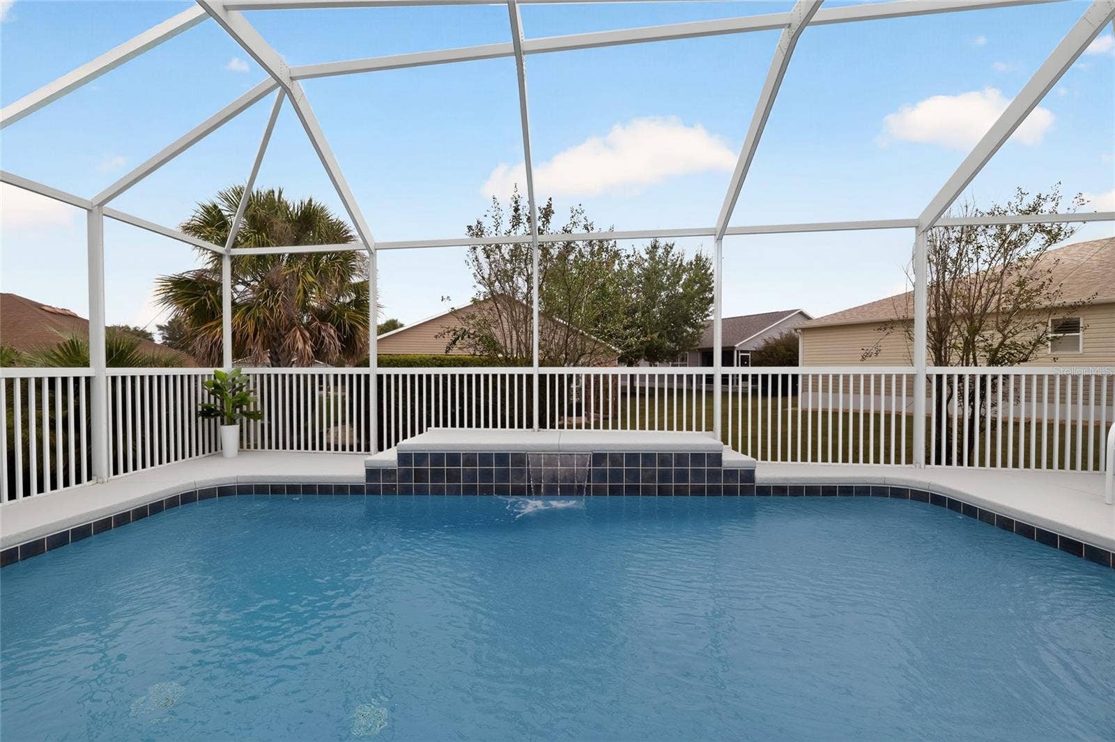 2454 MORNING DOVE LANE, The Villages, FL 32162 Enjoy a refreshing dip in the sparkling pool while the soothing waterfall creates a relaxing retreat beneath the spacious screened birdcage.