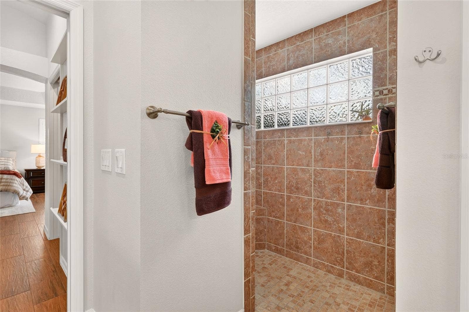 2454 MORNING DOVE LANE, The Villages, FL 32162 The beautifully tiled ROMAN SHOWER features a doorless entry and a GLASS-BLOCK WINDOW that welcomes natural light while maintaining privacy.