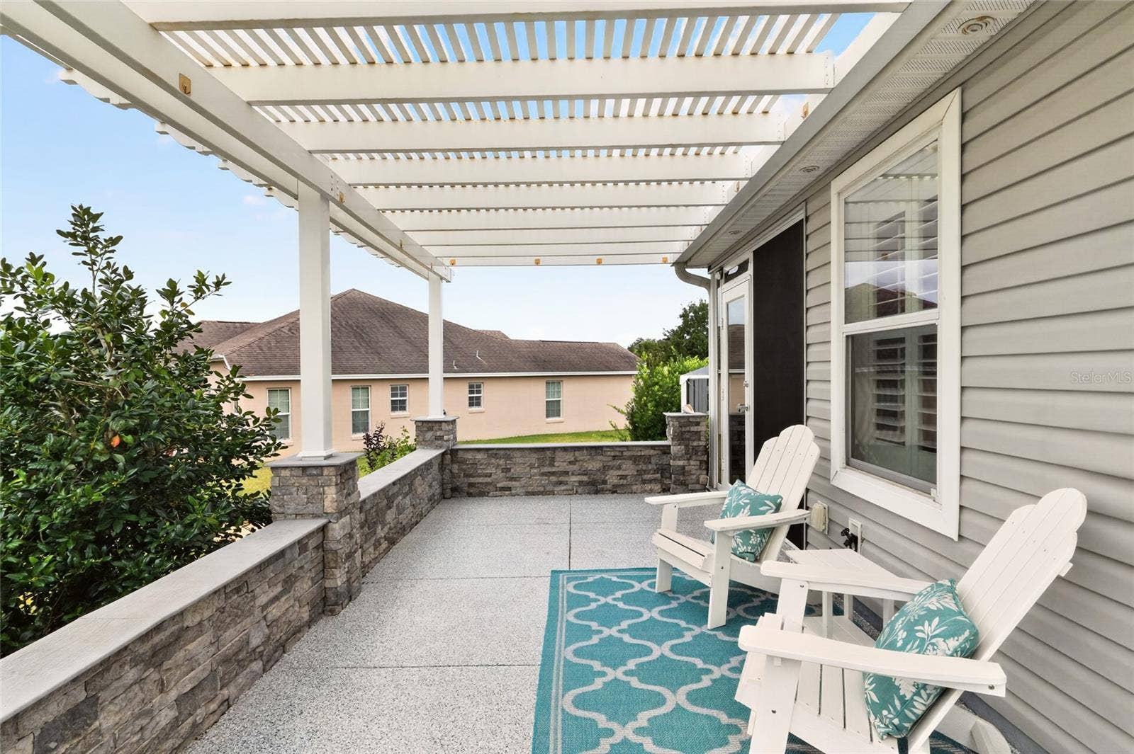 2454 MORNING DOVE LANE, The Villages, FL 32162 Relax beneath the charming pergola on this inviting patio, surrounded by lush landscapinga lovely setting for morning coffee or an evening with friends.