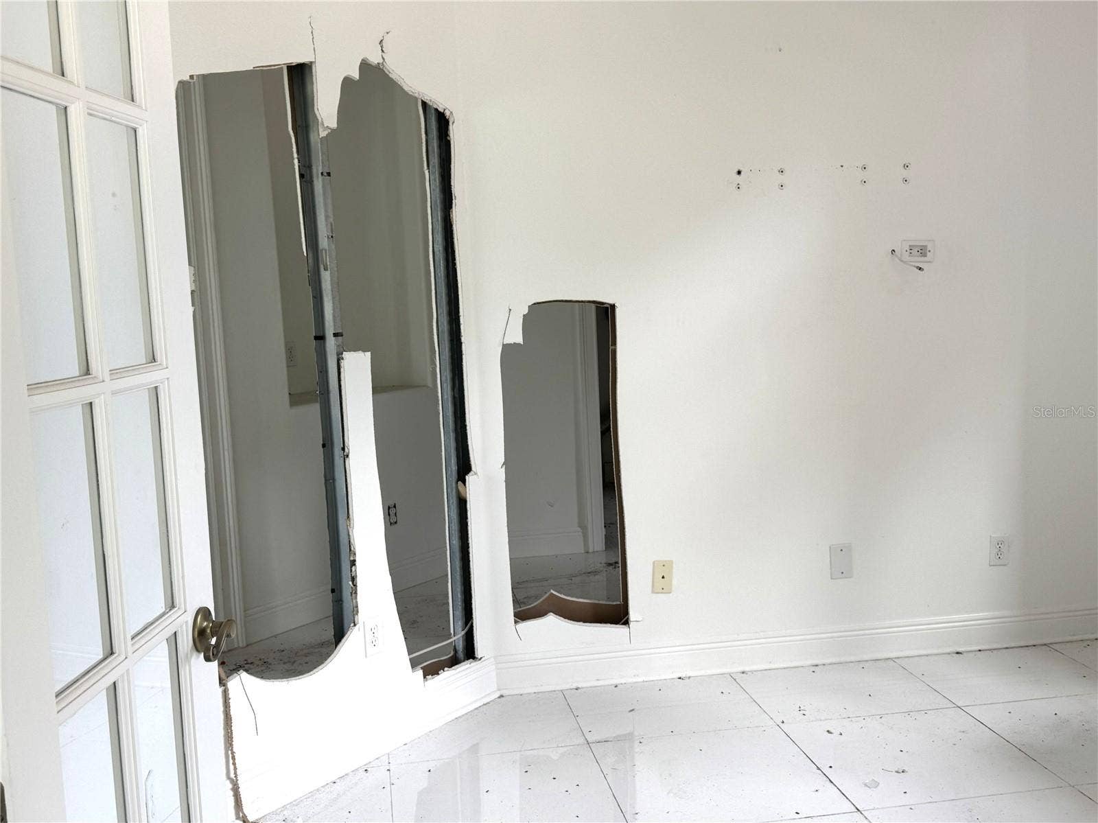 39539 HARBOR HILLS BOULEVARD, Lady Lake, FL 32159 Study/den with missing drywall and exposed wall framing requiring restoration.