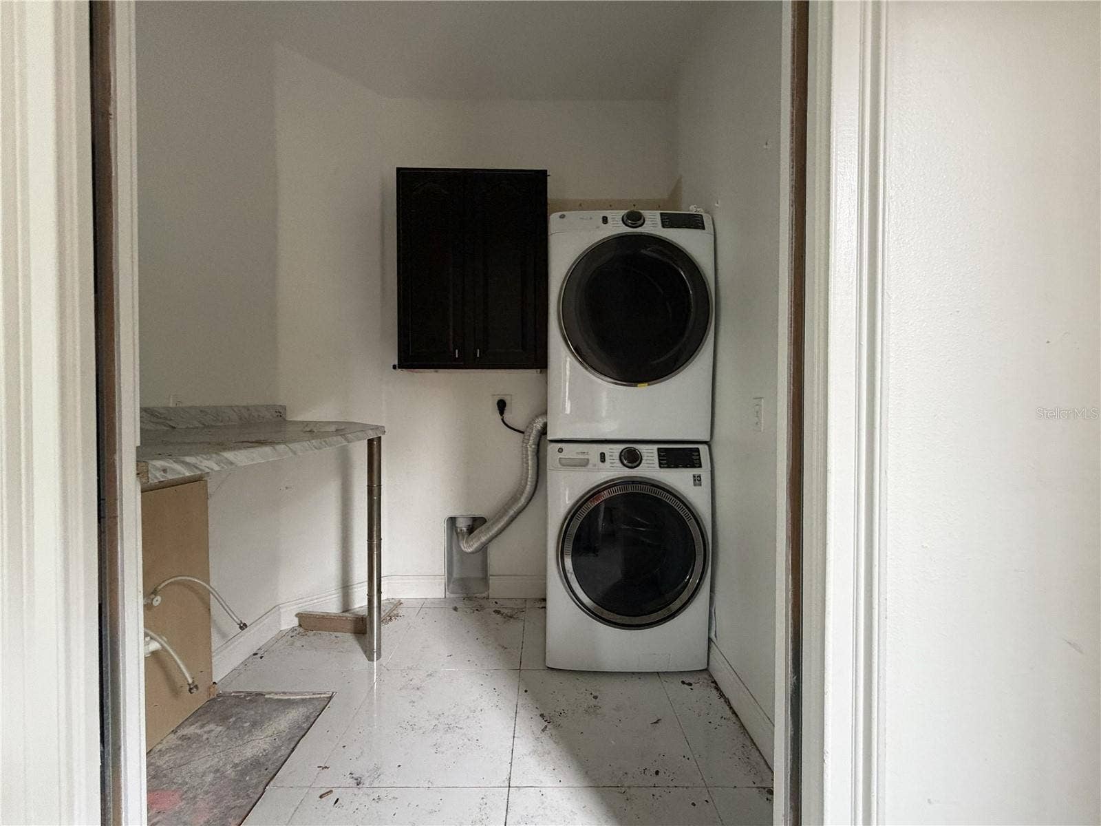 39539 HARBOR HILLS BOULEVARD, Lady Lake, FL 32159 Laundry room with stacked appliances; utility sink and lower cabinetry removed.