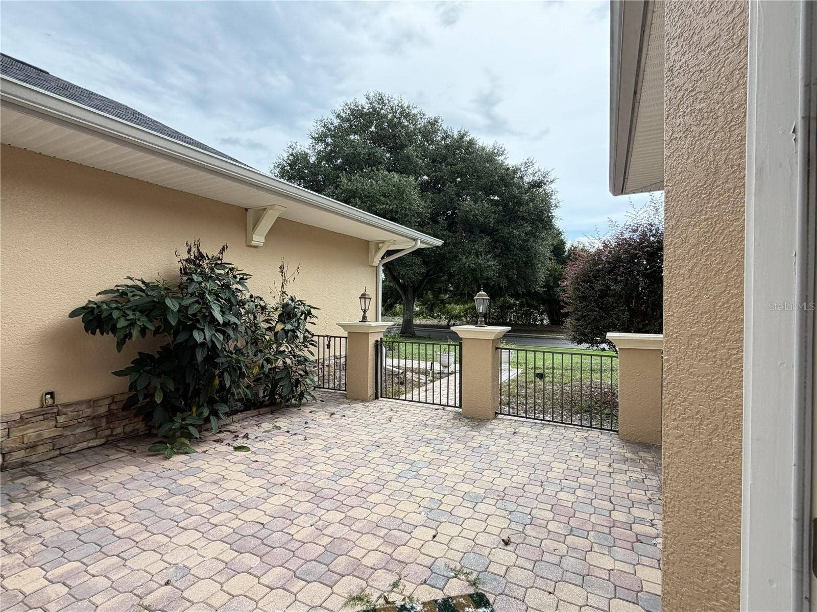 39539 HARBOR HILLS BOULEVARD, Lady Lake, FL 32159 Paver entry courtyard with decorative metal fencing.