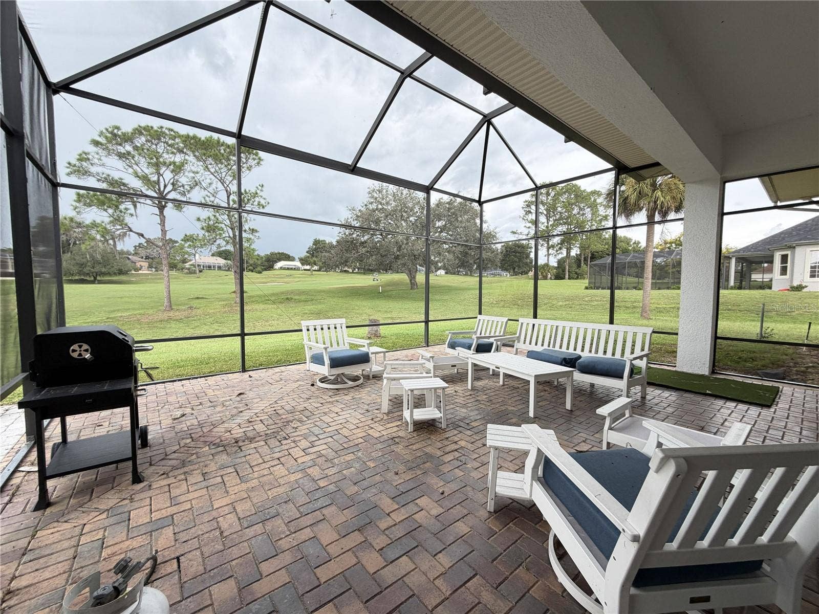 39539 HARBOR HILLS BOULEVARD, Lady Lake, FL 32159 Additional golf-course view from the lanai; portions of lower screening are missing.