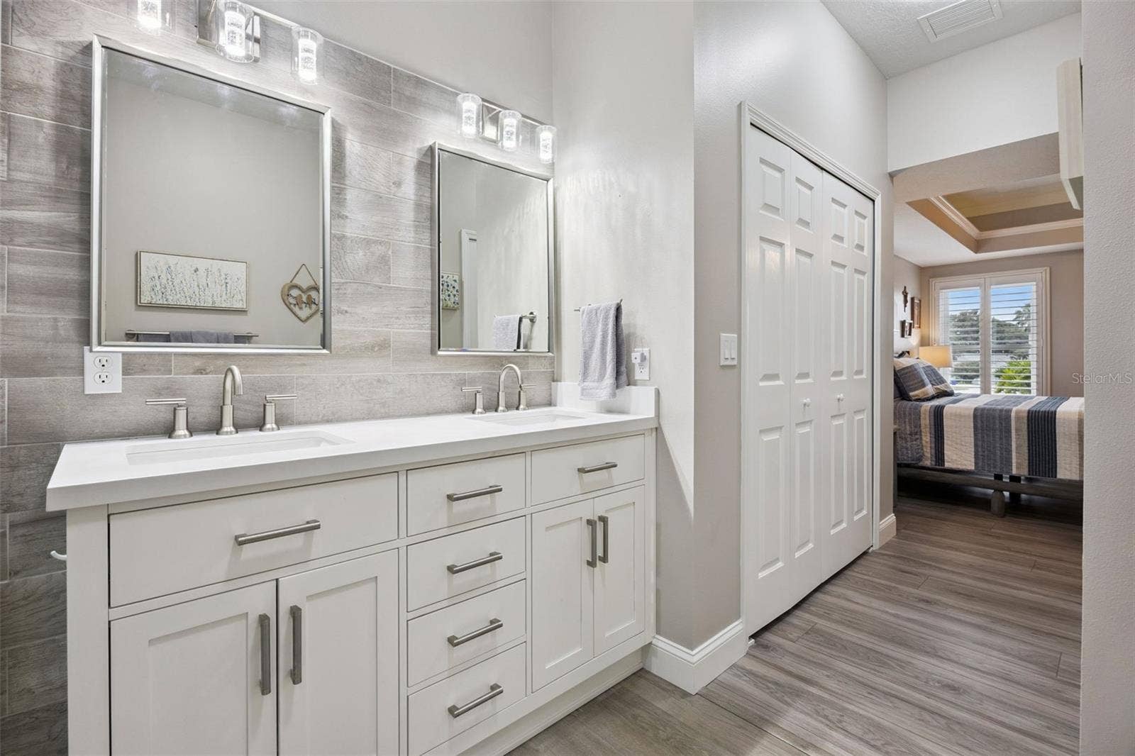 3210 SARATOGA DRIVE, Tavares, FL 32778 Dual sinks, plenty of counter space, and a beautiful tile accent wall make getting ready a little more enjoyable