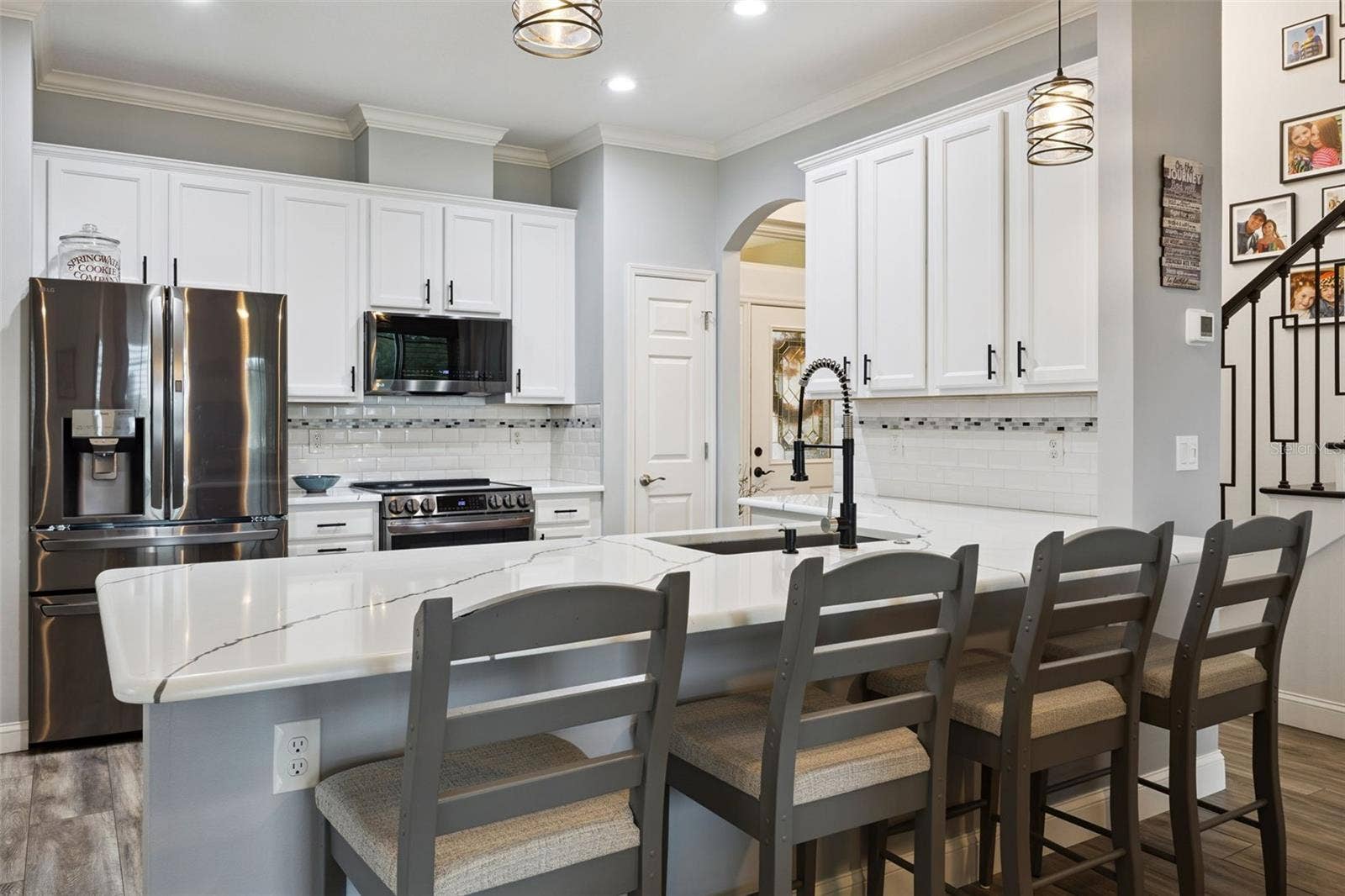 3210 SARATOGA DRIVE, Tavares, FL 32778 Stylish pendant lighting and freshly repainted solid wood cabinets give this kitchen a bright, polished look.