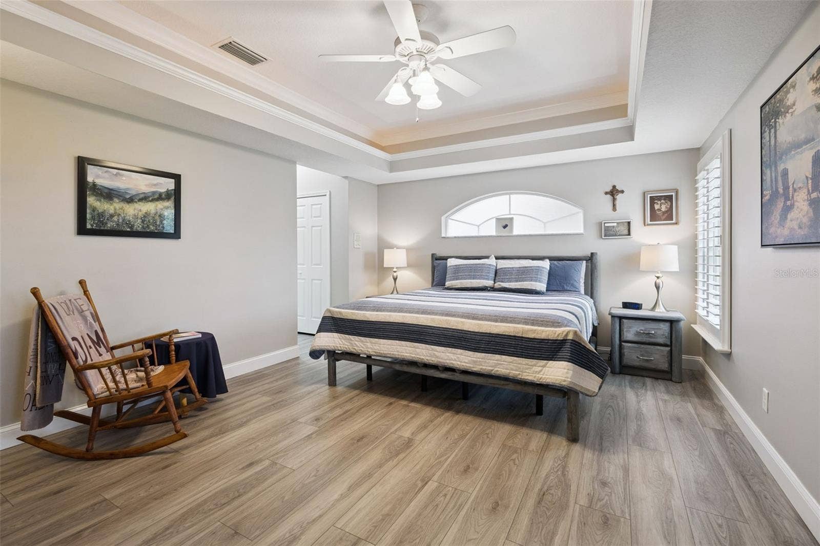 3210 SARATOGA DRIVE, Tavares, FL 32778 An arched window adds architectural charm to the spacious primary bedroom, with room for a cozy reading corner