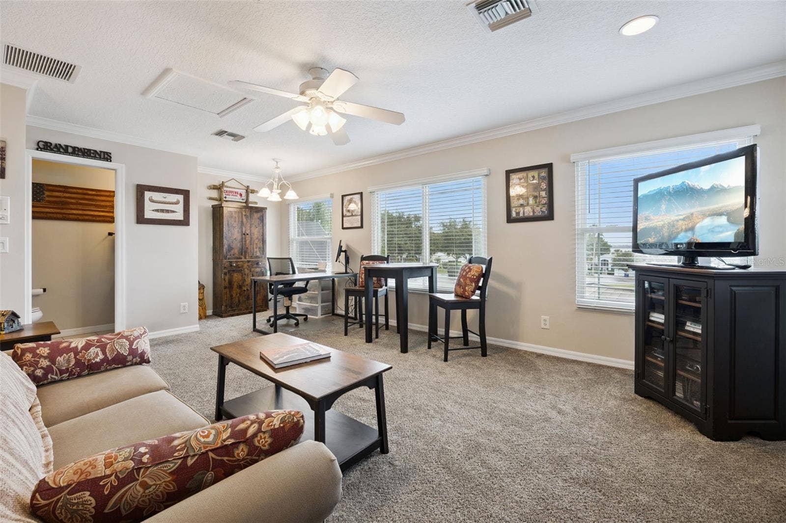 3210 SARATOGA DRIVE, Tavares, FL 32778 Upgraded carpeting makes this space extra cozy, with a convenient half bath just steps away