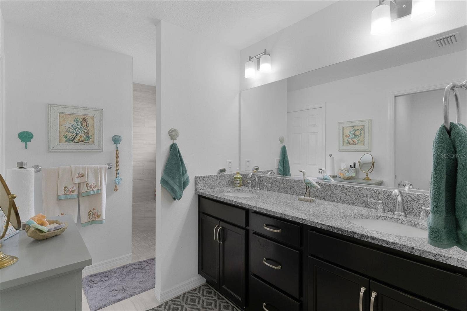 Dual sinks with granite countertops & Roman shower.