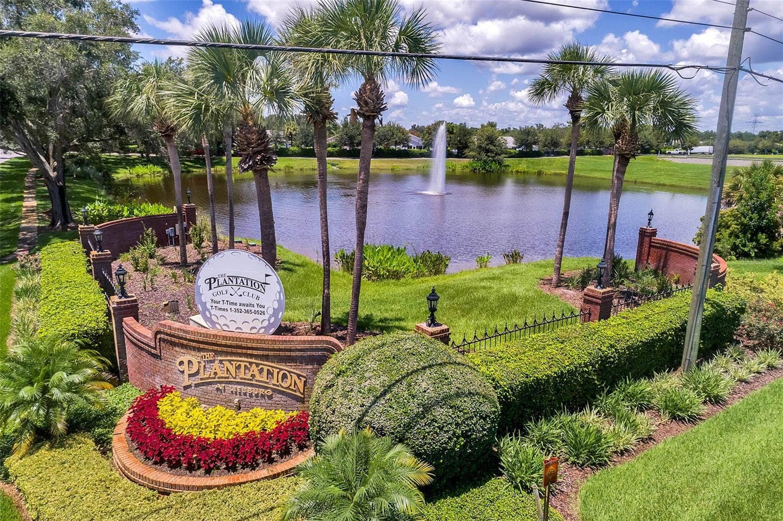 Community amenity: entrance sign with a fountain pond and palm trees