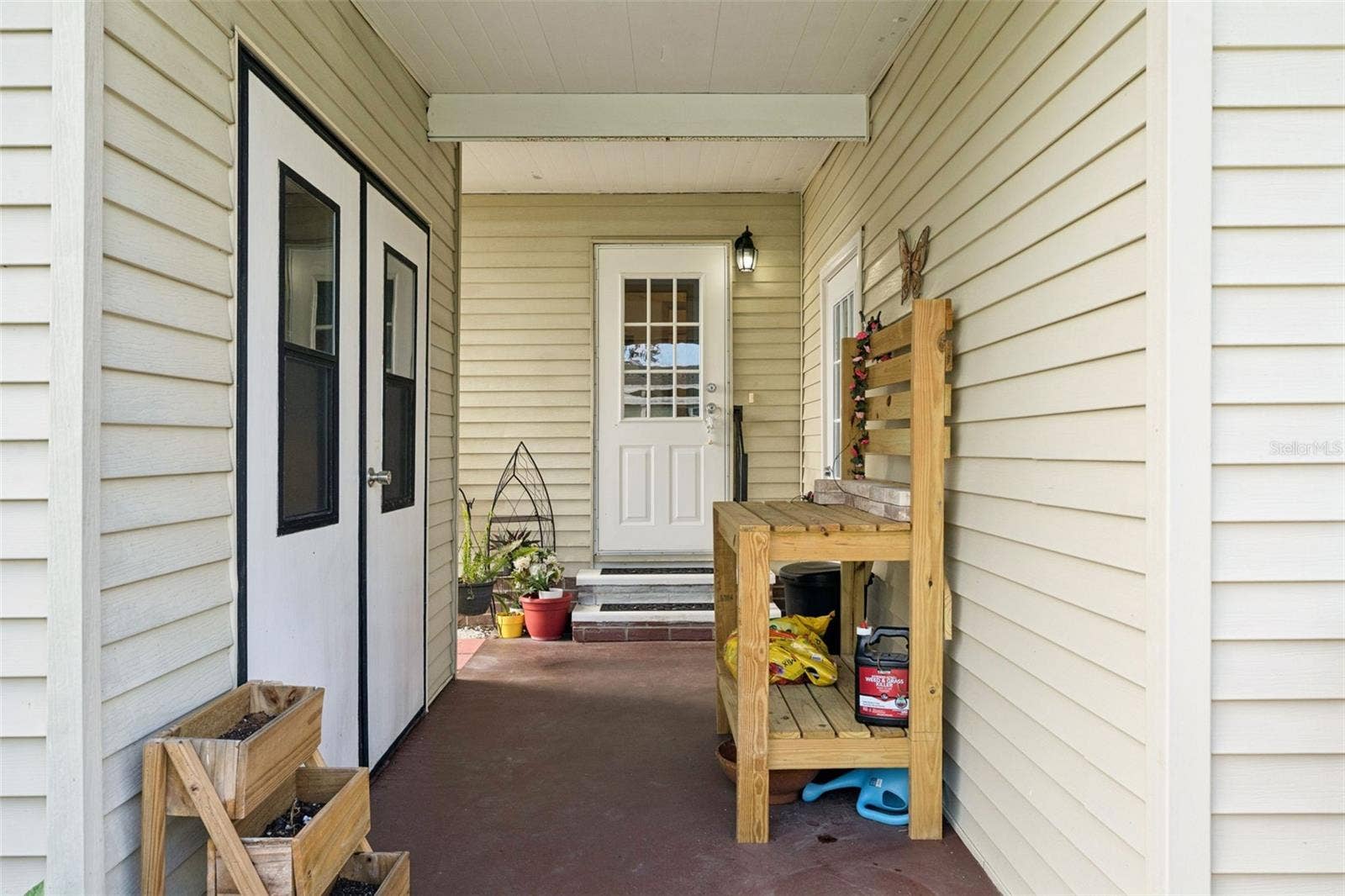 Covered front porch at the main entry, with double doors to the exterior storage room