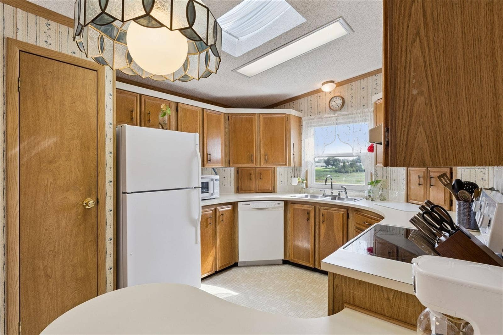 Kitchen with skylight, wood cabinetry, and a window over the sink overlooking the marsh