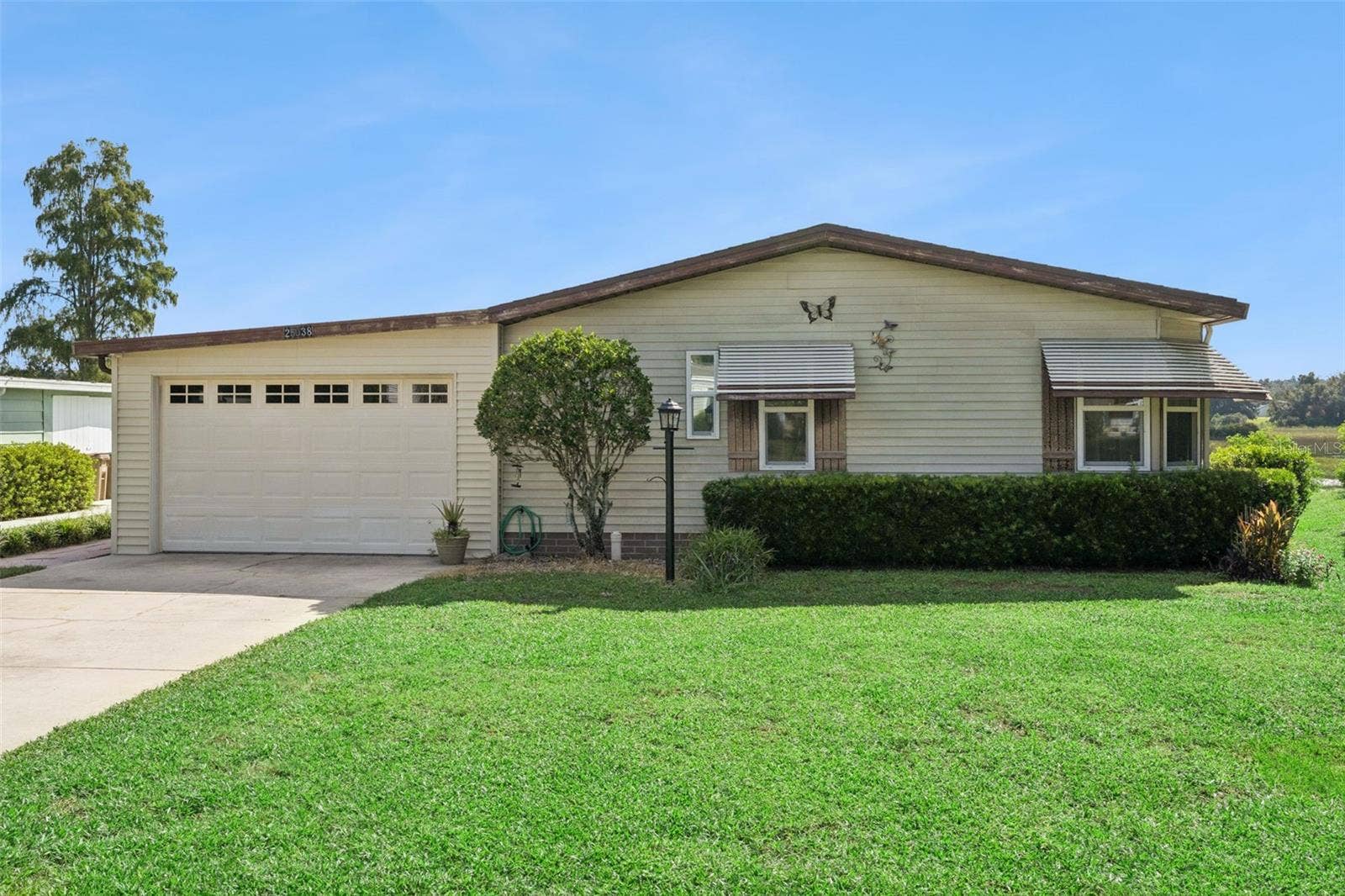 Front exterior with attached garage, wide driveway and landscaped front yard