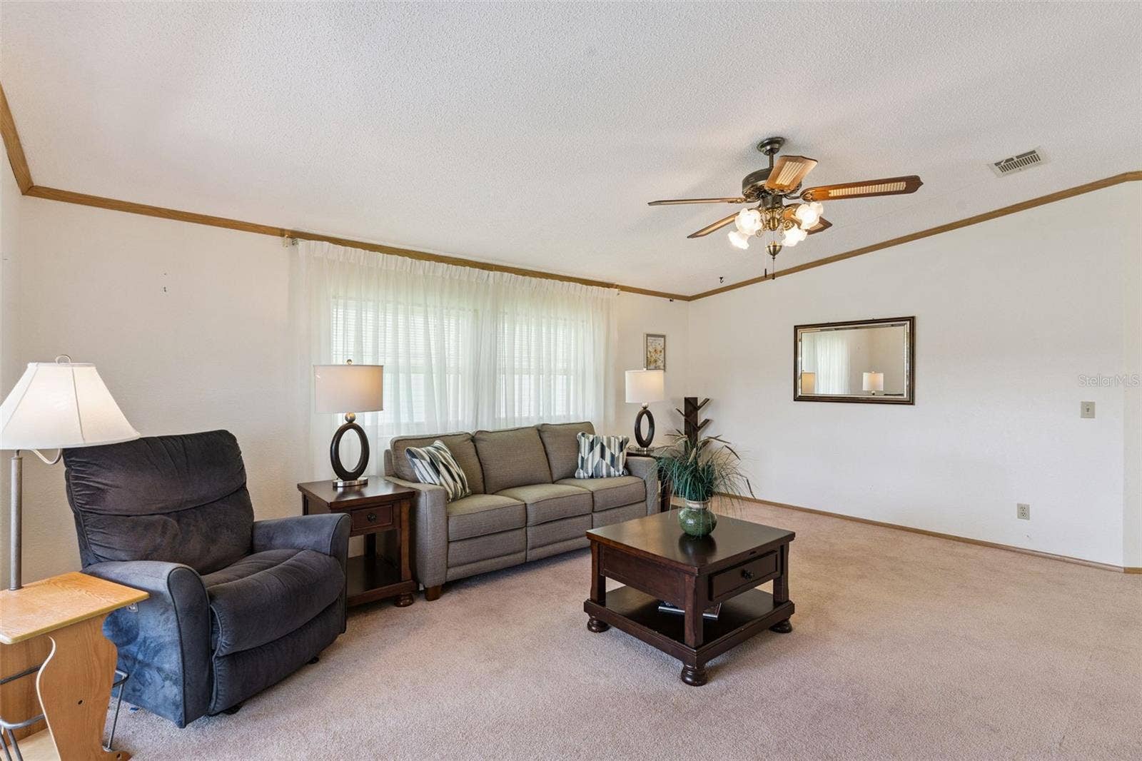 Living room with large front windows and a vaulted ceiling