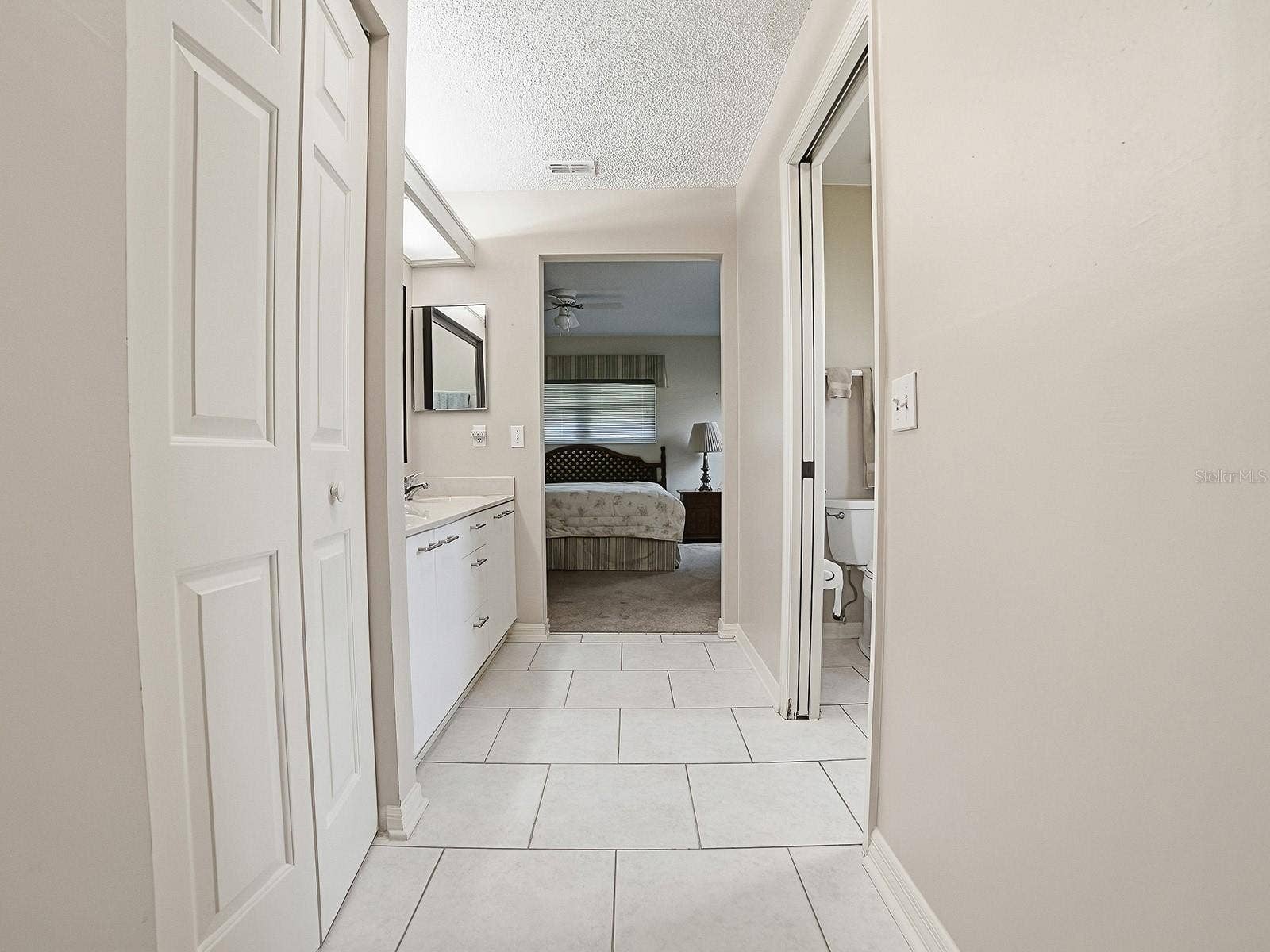 VIEW FROM PRIMARY BEDROOM THROUGH BATHROOM AND TO THE CRAFT/OFFICE/LAUNDRY AREA