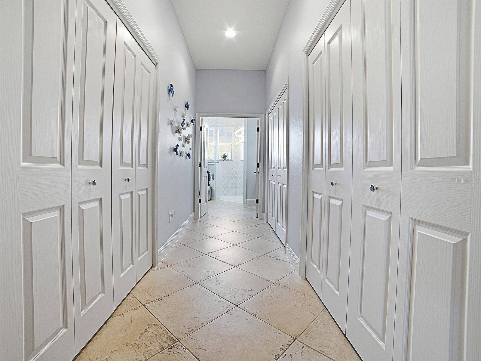 1103 MIONA SHORES DRIVE, The Villages, FL 32162 LARGE WALK-IN CLOSET ON THE LEFT WITH SOLAR TUBE, AND ON THE RIGHT MORE CLOSET SPACE. THE 2ND SET OF DOUBLE DOORS ON THE RIGHT HAS MORE STORAGE AND 2ND WATER HEATER - CONVENIENT FOR THIS SIDE OF THE HOME.