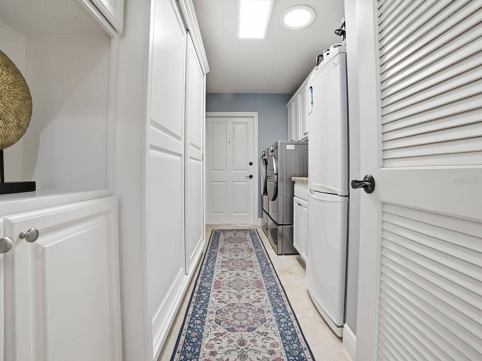 1103 MIONA SHORES DRIVE, The Villages, FL 32162 THE LAUNDRY ROOM HAS A NEW FRONT LOAD WASHER AND DRYER, A SINK, AND ALL THE CABINET SPACE YOU SEE HAS BEEN ADDED OFFERING SO MUCH EXTRA STORAGE. AN AREA FOR HANGING CLOTHES, SUPPLIES, AND EVEN A BROOM CLOSET.