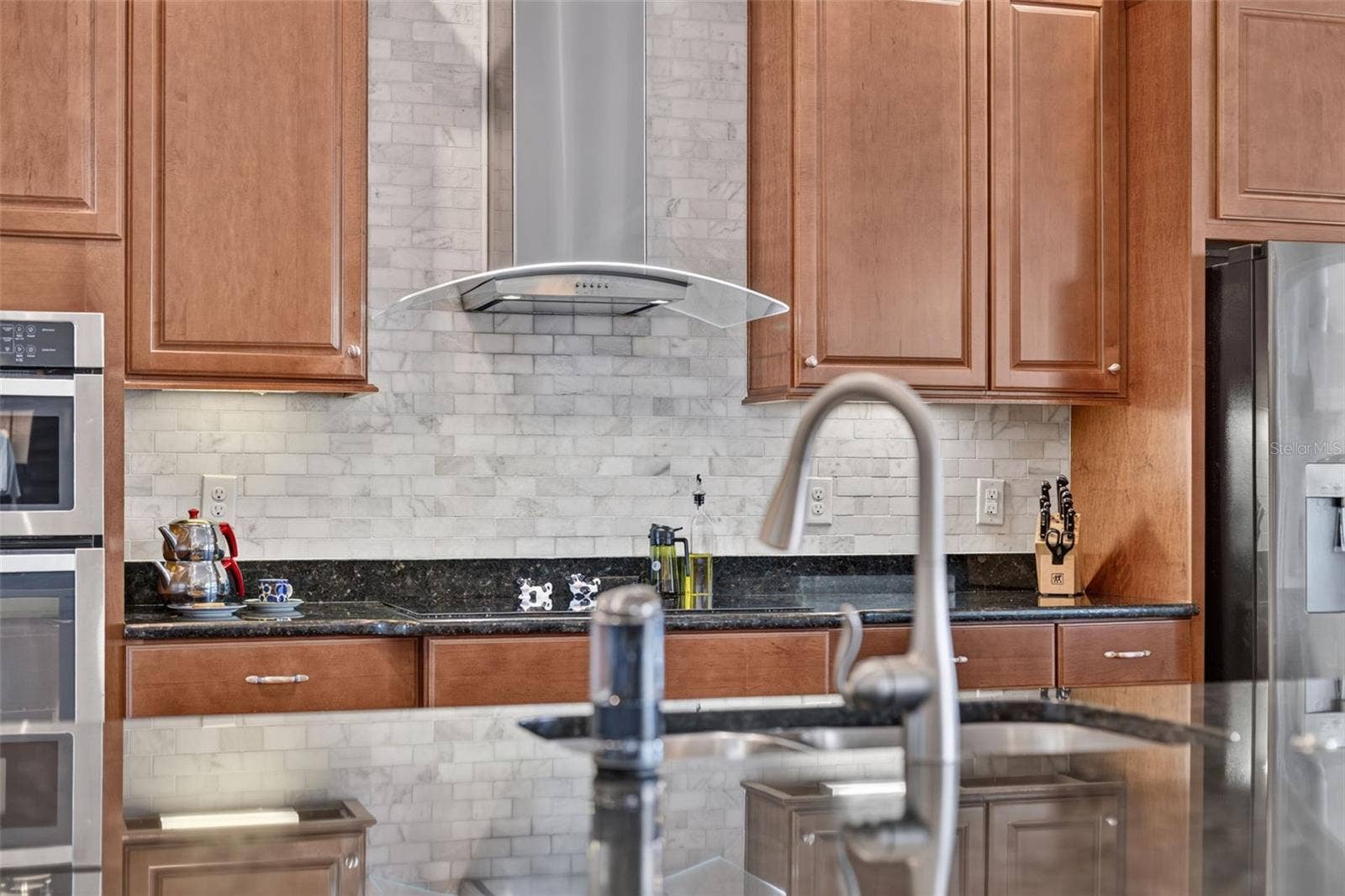 2444 PAWTUCKET PASS, Mount Dora, FL 32757 Rich wooden cabinetry, sleek granite countertops, and custom tilework make this gourmet kitchen an absolute chefs dream.