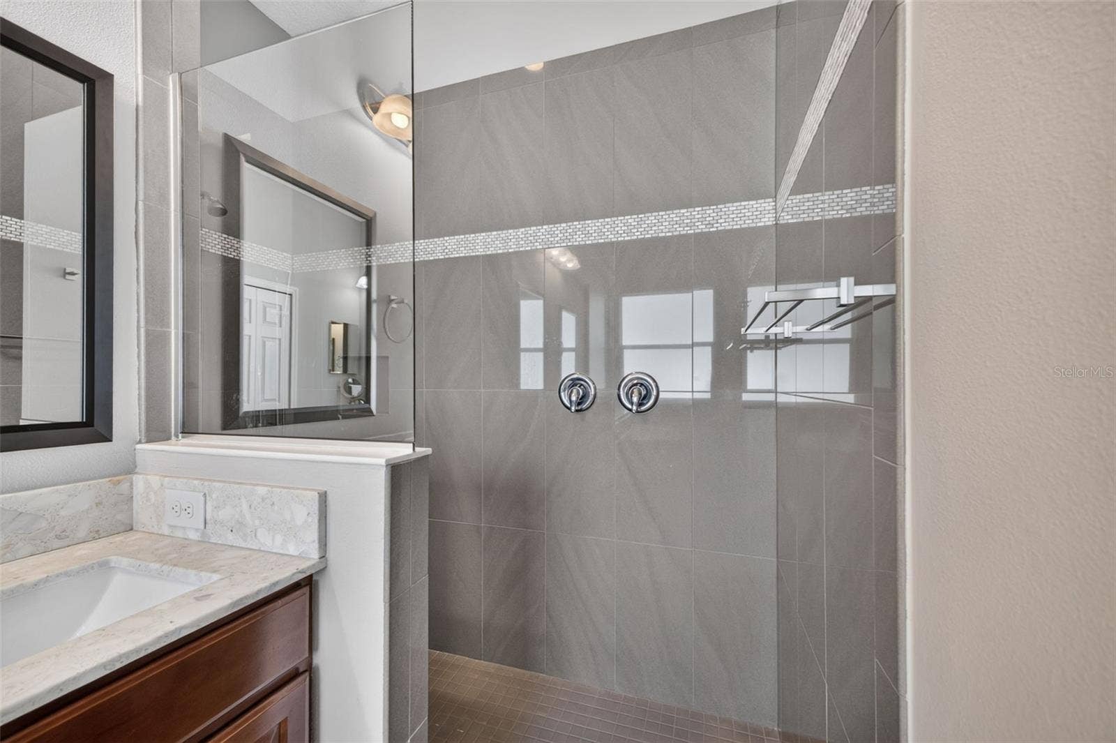 2444 PAWTUCKET PASS, Mount Dora, FL 32757 A separate, oversized walk-in shower features elegant tilework, offering a luxurious spa-like experience.