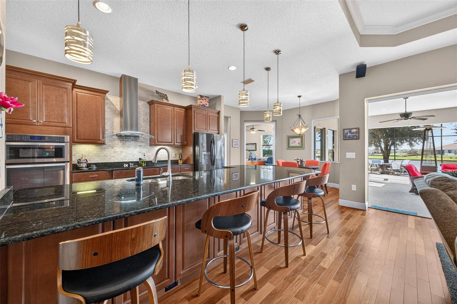 2444 PAWTUCKET PASS, Mount Dora, FL 32757 Durable granite countertops and rich wooden cabinetry elevate the kitchen, while a generous peninsula offers both extra storage and a welcoming spot for casual seating.