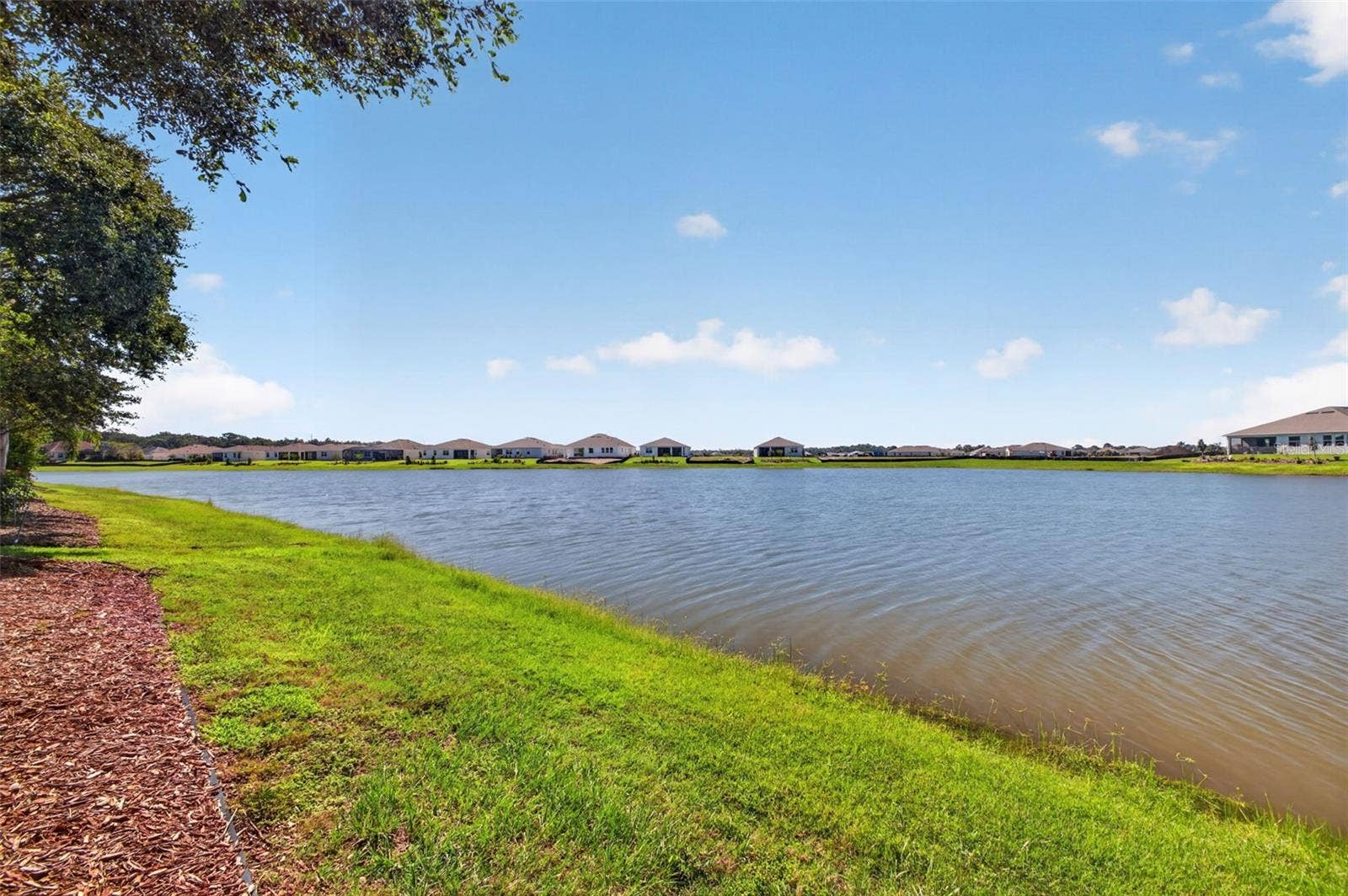2444 PAWTUCKET PASS, Mount Dora, FL 32757 A tranquil perspective from the water's edge showcasing the private grounds and prime lakefront location of 2444 Pawtucket Pass.