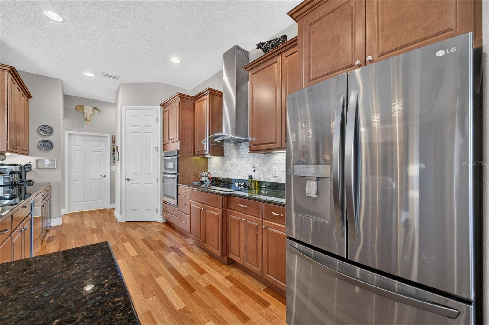2444 PAWTUCKET PASS, Mount Dora, FL 32757 Warm wood floors, sleek stainless steel appliances, and built-in convection microwave and oven units make this kitchen a chef's dream for culinary creations.