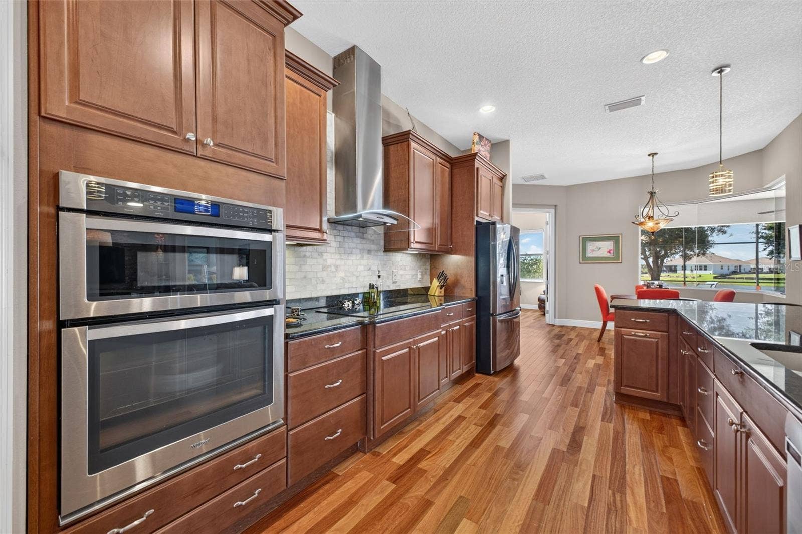 2444 PAWTUCKET PASS, Mount Dora, FL 32757 Equipped with a sleek induction cooktop paired with a stylish, exterior-vented range hood for optimal ventilation.