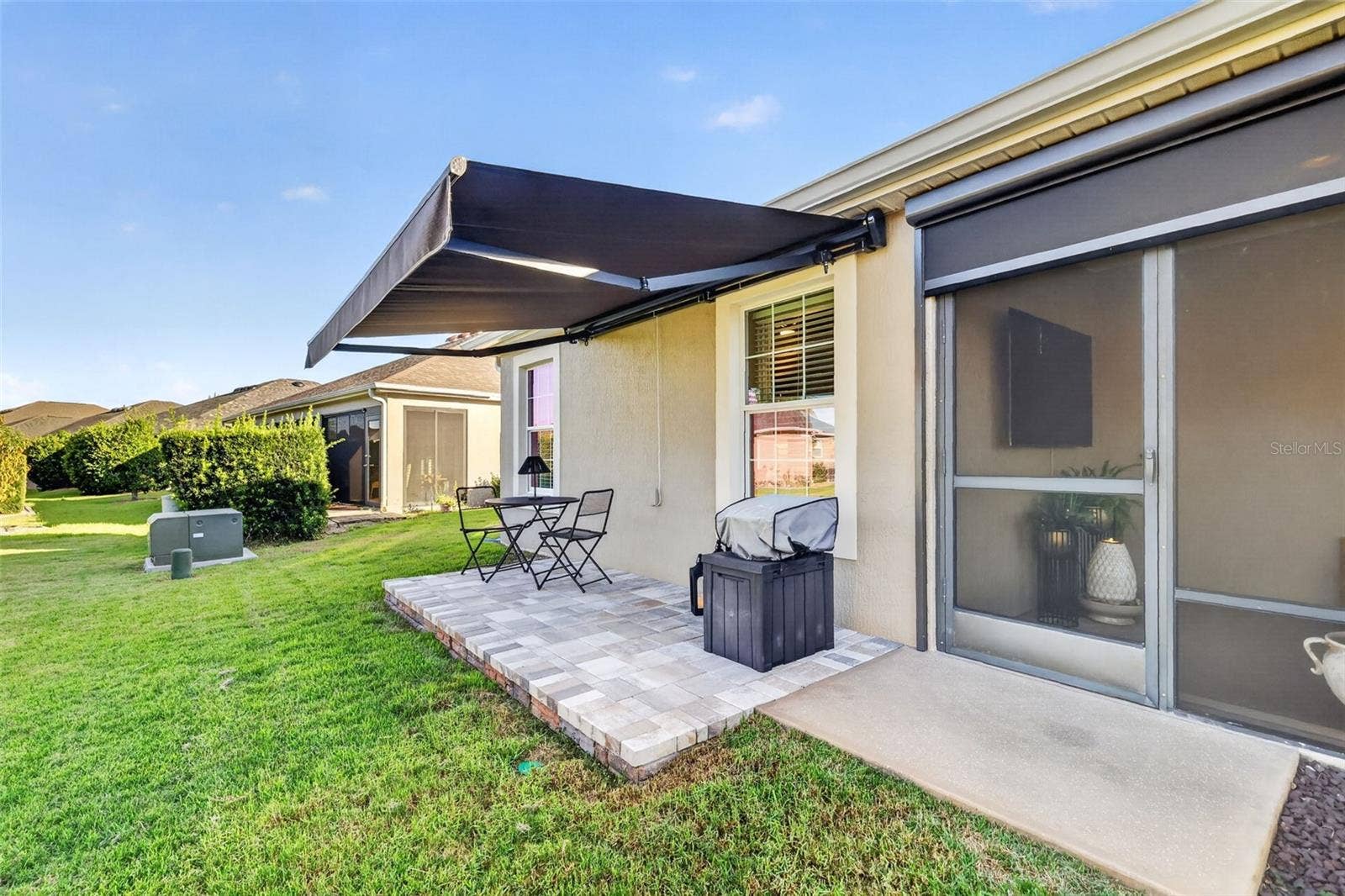 1793 WAX BERRY COURT, The Villages, FL 32163 Side Paver Patio with Remote-Controlled Awning