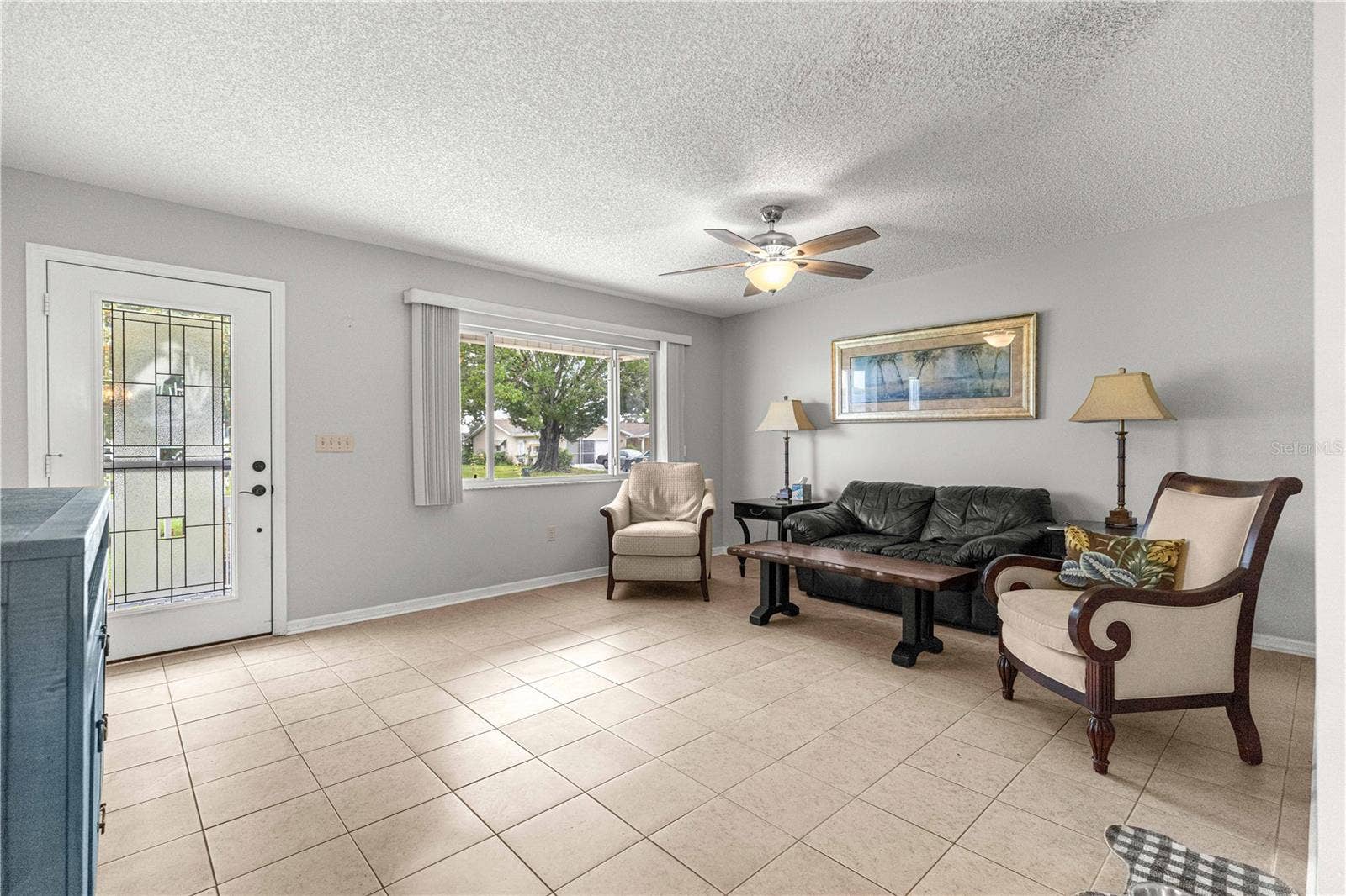 10434 SE 178TH PLACE, Summerfield, FL 34491 LIVING ROOM TO FRONT DOOR AND WINDOW DISPLAYING TILED FLOOR AND NEWER FAN