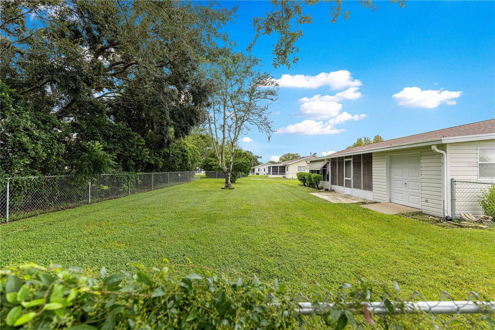 10434 SE 178TH PLACE, Summerfield, FL 34491 FENCED IN BACKYARD SHOWING BACK OF THE HOUSE AND GOLF-CART GARAGE