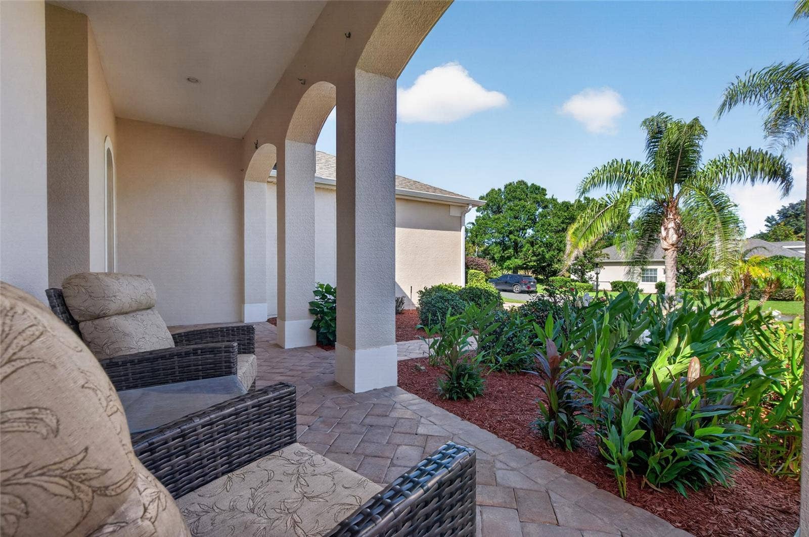 24151 BELLE MEDE DRIVE, Leesburg, FL 34748 FRONT COVERED PORCH WITH. COFFE HERE IN THE MORNING AND YOU CAN CATCH A GLIMPSE OF A POND.