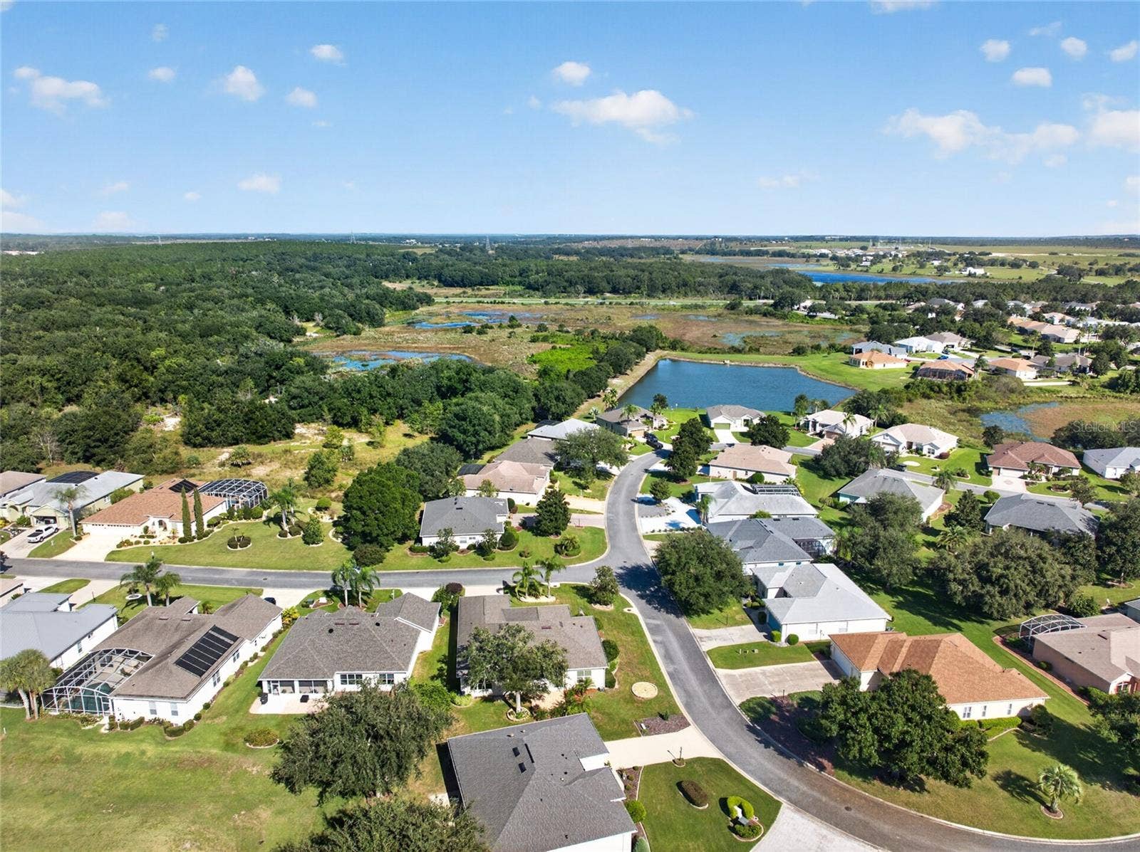 24151 BELLE MEDE DRIVE, Leesburg, FL 34748 WHEN YOU ARE SITTING ON THE FRONT PORCH YOU HAVE A GLIMPSE OF THE POND IN THE BACKGROUND